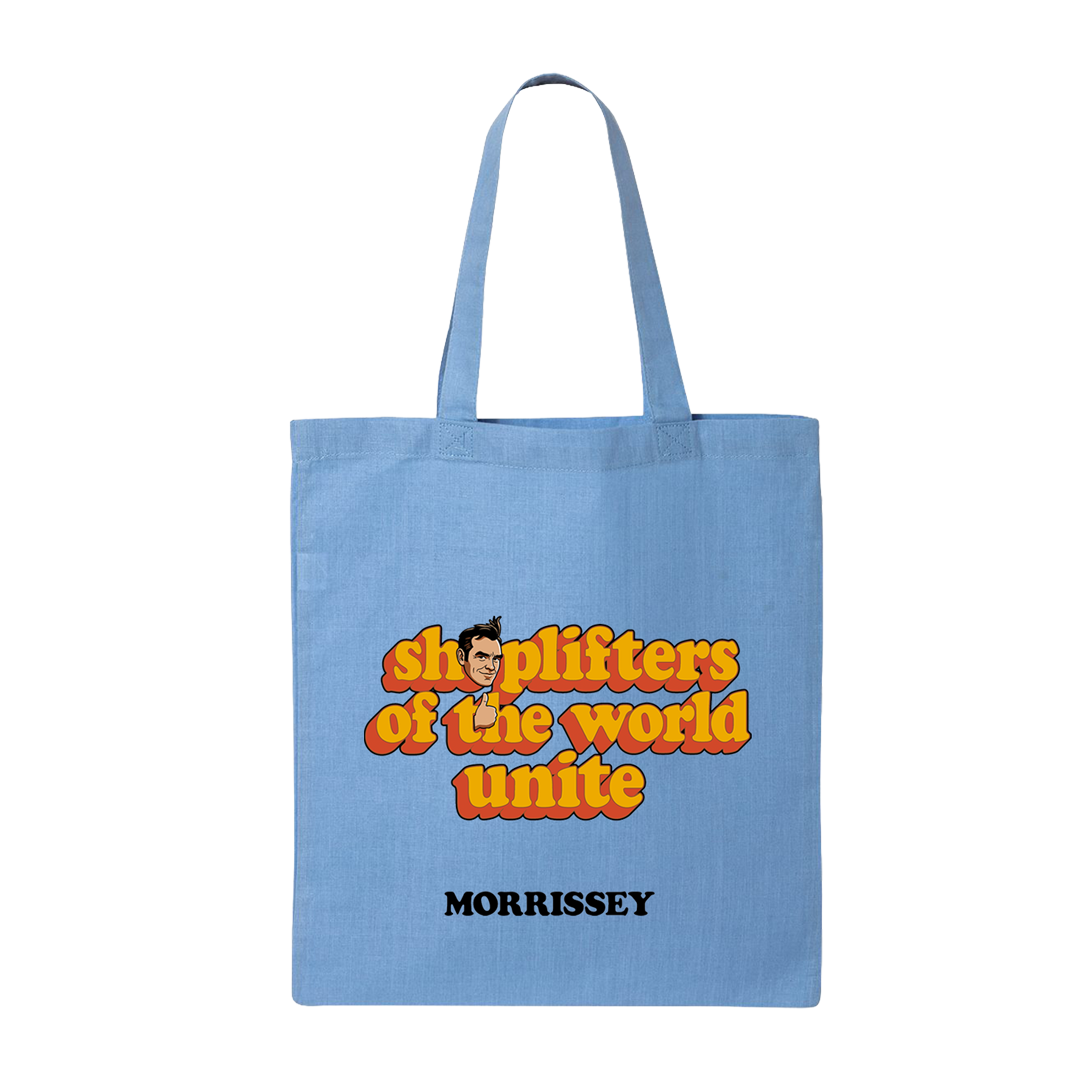 A light blue canvas tote bag with two shoulder straps, featuring a retro-style graphic that reads 'shoplifters of the world unite' in orange and yellow bubble letters with a cartoon face, and the name 'MORRISSEY' printed below in black.