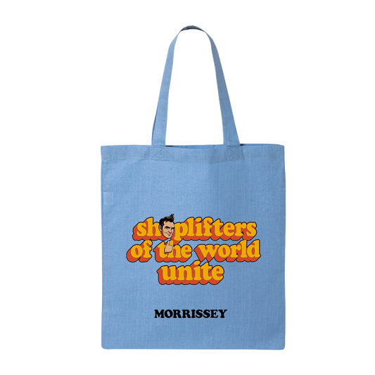 A light blue canvas tote bag with two shoulder straps, featuring a retro-style graphic that reads 'shoplifters of the world unite' in orange and yellow bubble letters with a cartoon face, and the name 'MORRISSEY' printed below in black.